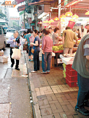 店舖佔用行人路經營，途人被迫走出行車路。（讀者提供）