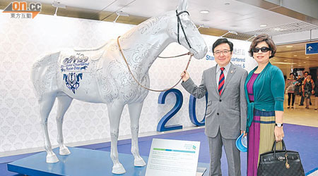 鄭錦鐘（左）夫婦喺匹模型馬前作狀拉頭馬，結果願望成真。