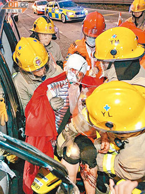 運菜車女乘客頭部重傷被困，由消防員救出。（張曉楠攝）