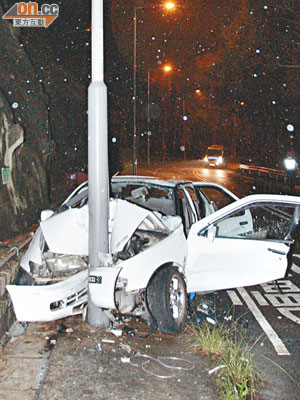 私家車失控直撞燈柱，車頭嚴重損毀。（蕭偉健攝）