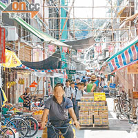 滿載貨物的電動唧車駛經橫街窄巷，途人均需閃避。