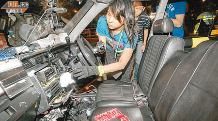 女警搜查涉案的士車廂。（呂浩鋒攝）