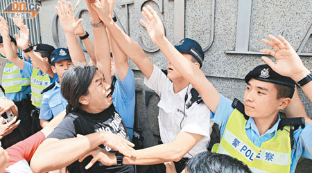 社民連長毛梁國雄昨圖將紙飛機拋入美國駐港總領事館，但被警方阻止。