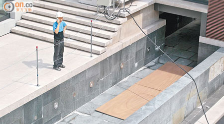 工人用木板將僭建地庫上方的泳池天窗覆蓋。（高嘉業攝）