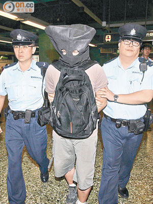 涉嫌在深水埗站偷拍裙底的大專學生被警員帶署。（林耀康攝）
