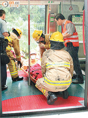 消防員將跳軌老翁由路軌救出，他送院時不斷呻吟。（何耀其攝）