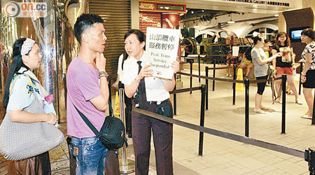 職員手持通告通知遊客纜車暫停服務。