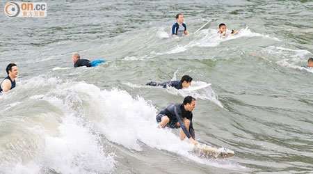 「飛燕」捲起大浪，但不少市民趁機到沙灘滑浪。（陸智豪攝）