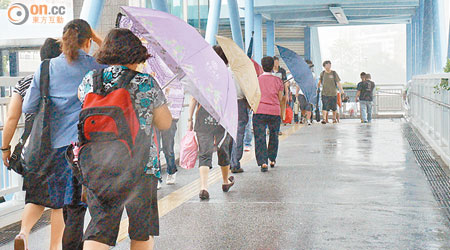 橫風橫雨下，居民行經超高上蓋天橋時均需打傘前行。