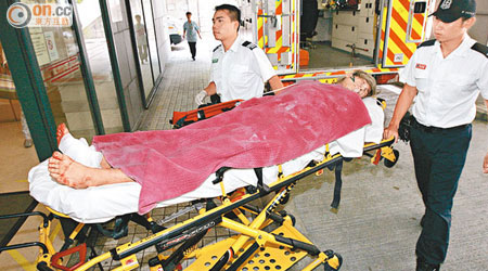 受傷青年由救護車送院治療。（梁卓明攝）