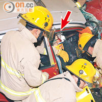 的士司機（箭嘴示）被困在車內，多名消防員設法拯救。