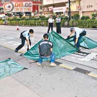 警員張開帳篷蓋着屍體及血肉。（楊偉嶽攝）