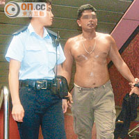 其中一名疑匪由警員押出港鐵站。（梁少恒攝）
