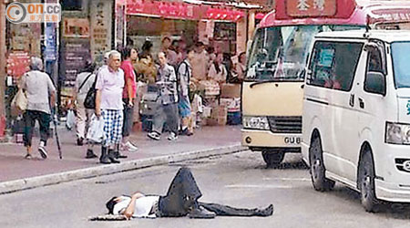 醉漢躺在馬路中心，車輛小心翼翼駛過。（讀者Stanley Chung提供）