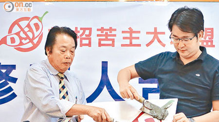 江羨祥（左）與何民傑（右）以水泥等批盪工具掩蓋「辣招」圖案，要求政府盡快「減辣」。（陸建宏攝）