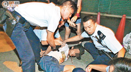涉嫌襲警男子被警員制服按在地上。（高潤榮攝） 