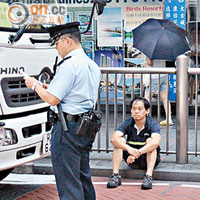 貨車司機（坐地者）在女事主被車撞現場協助警員調查。