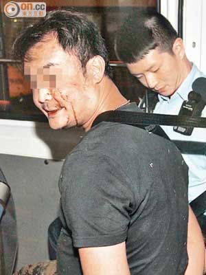 涉案被捕男子由警員帶署扣查。（左蘭慶攝）