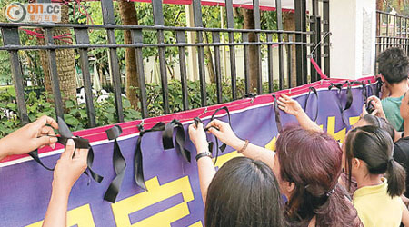 約卅名屯門極樂寺關注團體成員及附近居民將黑絲帶繫在鐵絲網表不滿。
