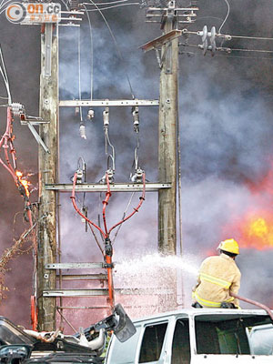大火波及電線杆，消防射水灌救。