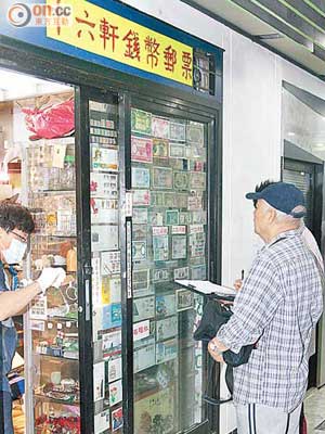 舊錢幣店老東主（右）在店外協助警方調查。（陳展鴻攝）