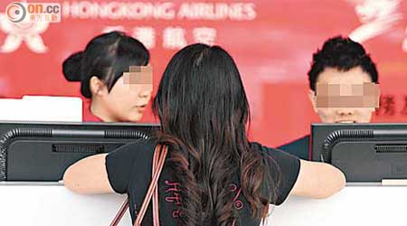 有顧客親身到機場香港快運櫃台，欲更改電子機票上的航班錯誤資料，但不得要領。（朱先儒攝）