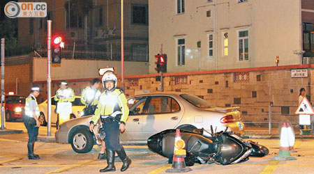 警員在電單車與私家車相撞現場調查。（梁少恒攝）