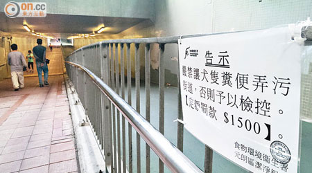 食環署於隧道欄杆張貼告示，提醒狗主勿讓狗隻便溺。