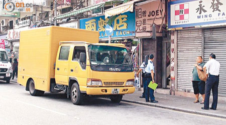 食環署貨車車頭的車頂被壓毀，司機（右二）在場助查。（吳欽旺攝）