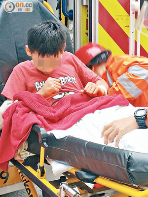男童情緒激動，被綁在擔架床上送院檢驗。