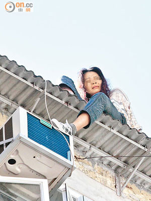 情困女子危坐天台簷篷。（梁卓明攝）