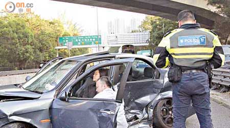 司機蹲在車旁安慰女傷者。（左錦鴻攝）