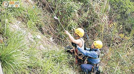 消防員游繩協助被困陡坡的男子返回路面。（左錦鴻攝）