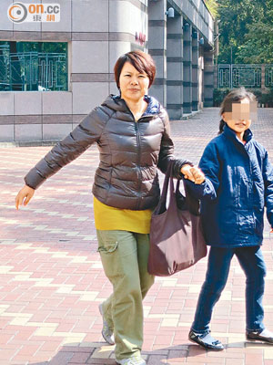 被告獲判緩刑後與女兒手牽手離開法院。