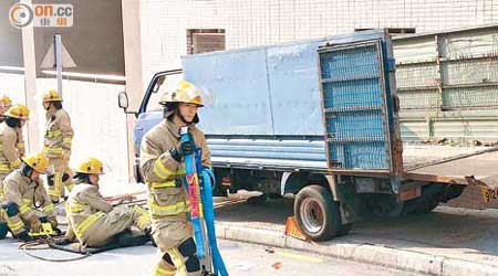 農夫車夾斃司機，消防員帶備工具拯救。（吳欽旺攝）