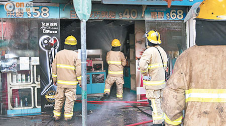 消防員向起火護髮用品中心射水。（吳欽旺攝）