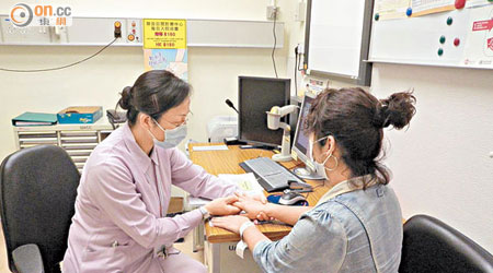 風濕科專科護士（左）向病人解釋風濕病對關節的影響。
