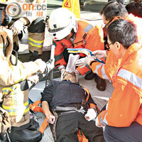 救護員為重傷工人急救，惟送院不治。（戴展邦攝）