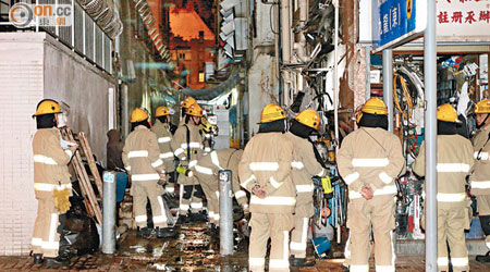 多名消防員在筲箕灣道縱火案現場調查。（張曉楠攝）