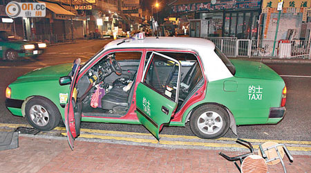 的士玻璃窗被砸碎，車旁遺下兩張圓櫈。（楊日權攝）