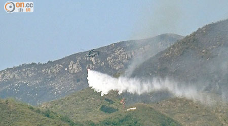 飛行服務隊不斷向起火山頭投擲水彈。（曾志恒攝）