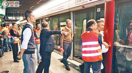 多名穿反光衣的港鐵人員在港鐵站內調查。（陳展鴻攝）