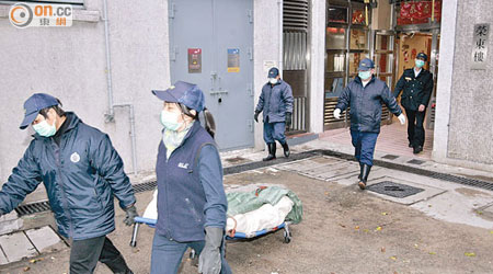 在東頭邨住所猝死的壯漢，其屍體由仵工舁送殮房。（馮裕亨攝）