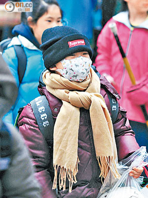 台灣持續遭寒流襲擊，民眾穿上禦寒衣物出行。（本報台北傳真）