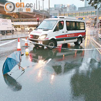 車禍現場遺下馮、吳共撐的雨傘。（張曉楠攝）