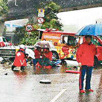 肇事客貨車移正停在路中，市民打傘為傷者擋雨。（互聯網圖片）