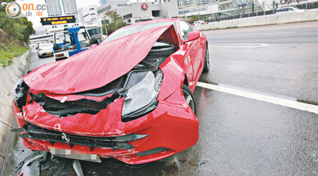 跑車撞石壆後，車頭嚴重損毀。（冼耀華攝）