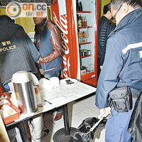 警員帶同警犬在小食店搜查。