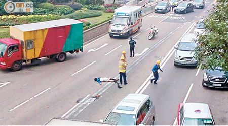 在遮打大廈天台跳樓男子，倒臥干諾道中行車線上。（呂耀焜攝）