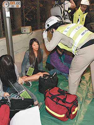 受傷小巴乘客坐在路旁接受急救。（林耀康攝）